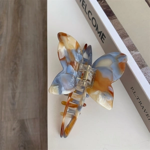 Detail of marble pattern acetate butterfly hair claw with Sunshine Handmade gold lettering