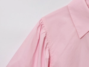 Detail shot of pink poplin shirt collar and pleated puff sleeve stitching texture