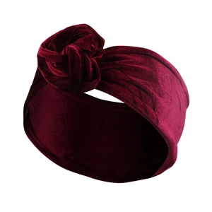 Detail eines weinroten Samthaarbands mit handgefertigtem Rosenknoten und weicher Textur