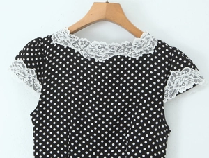 Détail de la robe noire à pois avec bordure en dentelle blanche au col et aux manches
