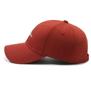 Rust red cotton baseball cap with white script embroidery and reinforced stitching