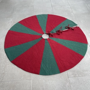 Detail of red and green striped knitted Christmas tree skirt with ribbon ties