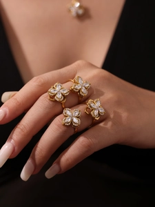 Close-up of golden four-leaf clover rings set with sparkling zircon on a female model