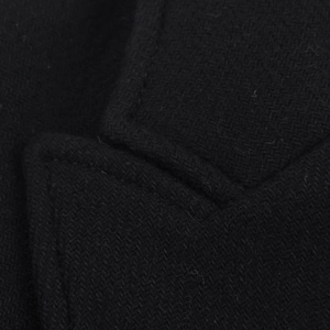 Detailed close-up of premium black herringbone wool blend fabric with precise stitching