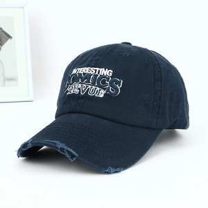 Close-up of distressed brim and vintage embroidery on this navy blue washed cotton cap