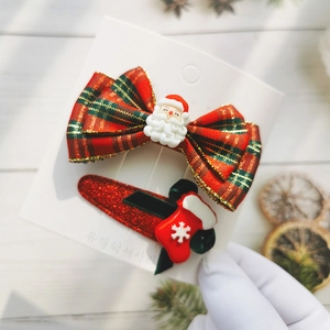 Detail of Christmas bow hair clips set with Santa Claus and stocking charms for girls