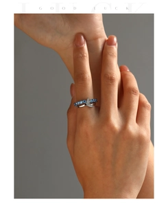 Macro detail of S925 silver mermaid tail ring with blue gradient sapphires and diamonds