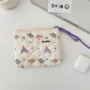 Detail of quilted fabric pouch with elephant print and long purple braided zipper pull