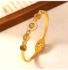 Macro shot of gold tree of life bangle with hollow design and inlaid white rhinestones