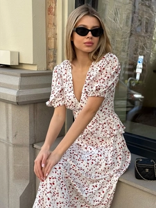 Détail de la robe à fleurs col en V avec manches bouffantes et motif de feuilles rouges