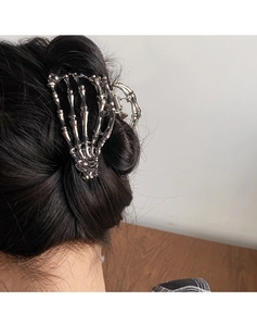 Close-up of gothic silver skull hand hair claw clip in a stylish half-up hairstyle