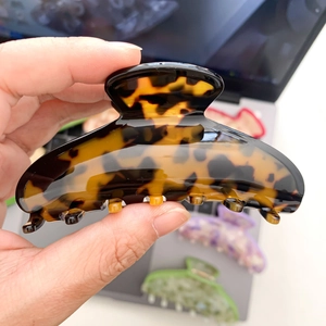 Tortoiseshell acetate hair claw clip with elegant curved design and secure grip teeth
