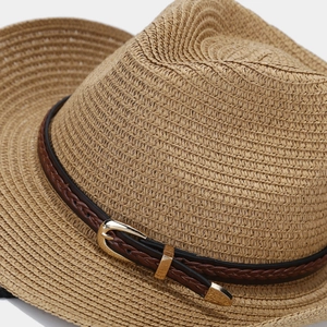 Detailed macro view of retro woven straw hat with brown leather buckle belt decoration