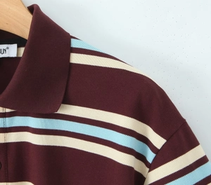 Detail of striped polo shirt showing burgundy and blue pique cotton fabric texture