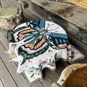 Detailed view of woven camping blanket featuring bohemian butterfly pattern and colorful tassels
