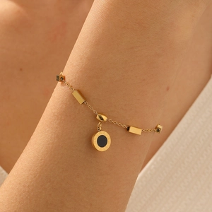 Vintage gold plated stainless steel bracelet with Roman numeral pendant on wrist