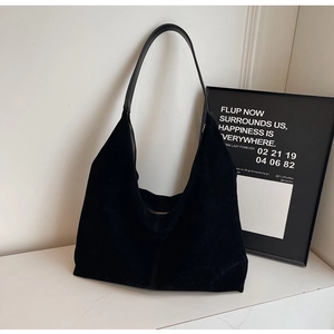 Macro view of matte black suede hobo bag with sleek leather strap and premium texture