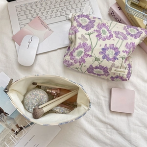 Macro detail of floral canvas makeup bag with durable zipper and purple flower prints