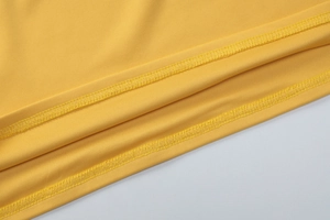Gros plan détaillé du tissu en maille jaune montrant les coutures et la texture