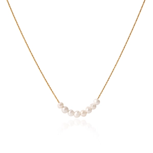 Detail of nine white freshwater pearls curved on a gold stainless steel necklace