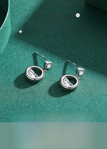 Macro shot of S925 sterling silver hollow round earrings with sparkling zircon stones