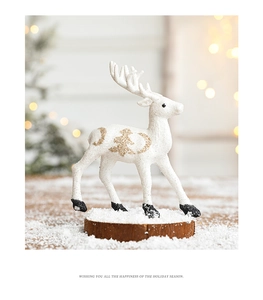 Close-up of a white glitter reindeer figurine with gold celestial patterns on a wooden base