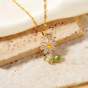 Collier tournesol doré élégant avec pétales blancs et feuilles vertes sur fond de soie