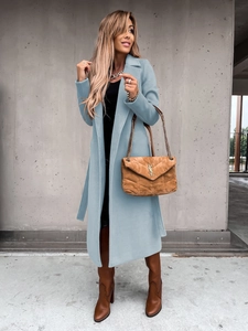 Detail of light blue wool coat with lapel collar and waist belt in minimalist style
