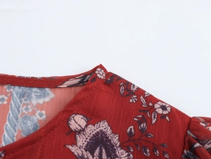 Close-up of the round neckline and vintage floral pattern on this red chiffon blouse