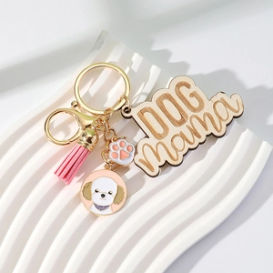 Detail of wooden Dog Mama keychain with pink tassel and dog paw enamel pendant