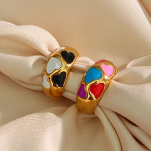 Detail of two vintage-style 18k gold plated rings with colorful enamel heart patterns