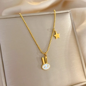 Macro detail of gold-plated rabbit pendant with mother of pearl inlay on bead chain