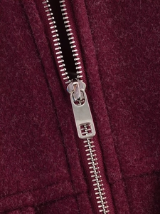 Dettaglio della cerniera in metallo argento su tessuto di lana rosso vino vintage