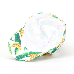 Close-up of tropical banana and palm leaf print on a white cotton baseball cap with mesh