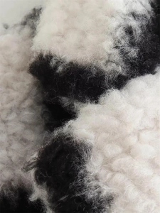 Close-up of the black and white plaid wool-like texture on a women's cocoon coat