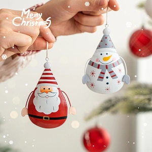 Nordic iron Santa and Snowman hanging ornaments held in hand against a festive Christmas tree