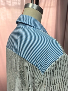Detail of blue striped fabric and shimmering silver sequins on a loose-fit sequin blazer