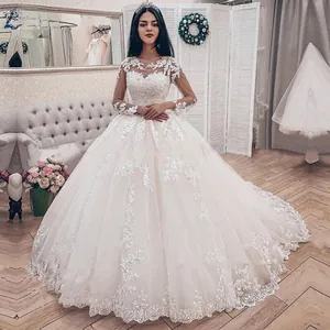 Detail showing the intricate lace embroidery and off-shoulder long sleeves of the wedding gown