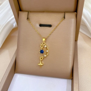 Macro detail of gold star and moon tassel necklace with blue gemstone in a box