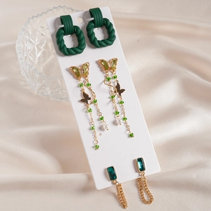 Six-piece acrylic butterfly tassel earrings set with green crystals on silk background