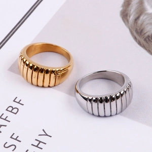 Macro detail of gold and silver croissant textured stainless steel wide band rings