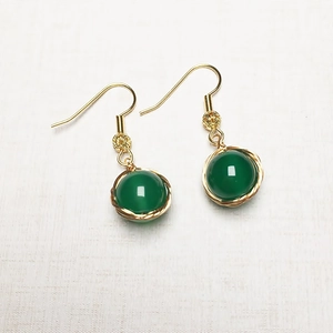 Détail de boucles d'oreilles en agate verte enveloppées de fil rempli d'or 14K