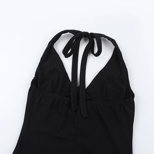 Detail of black halter neck dress featuring an open back with delicate tie-up straps