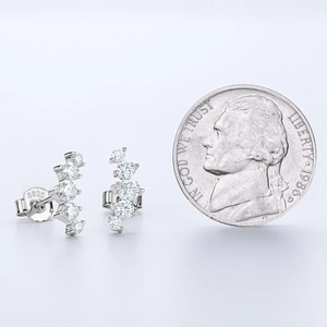 S925 sterling silver moissanite stud earring compared with a coin for size measurement