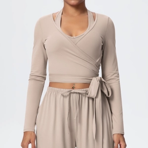 Detail of beige wrap yoga top with layered V-neck and soft brushed fabric texture