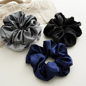 Three-piece satin scrunchie set in grey, black, and navy blue with elegant silky luster