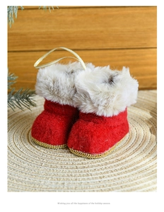 Detailed view of red felt Christmas boot ornament with faux fur trim on woven mat