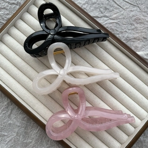 Close-up of black, cream, and pink jelly-colored hair claws on a jewelry display tray