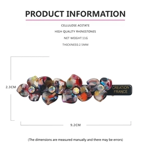 Detailed view of acetate flower hair clip with rhinestones and size measurements