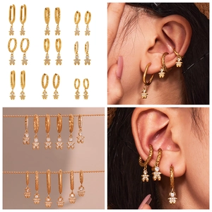 Detail showing nine gold-plated earrings with zircon-set little prince charms on models